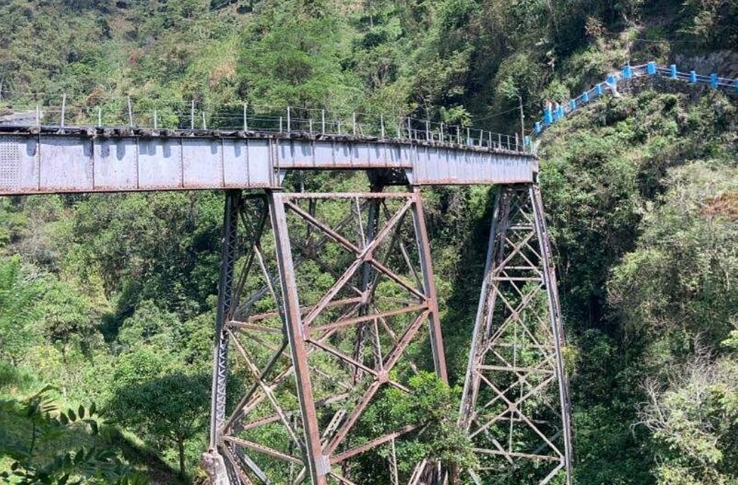A group of hikers sharing the railway route in the green mountains of Amagá